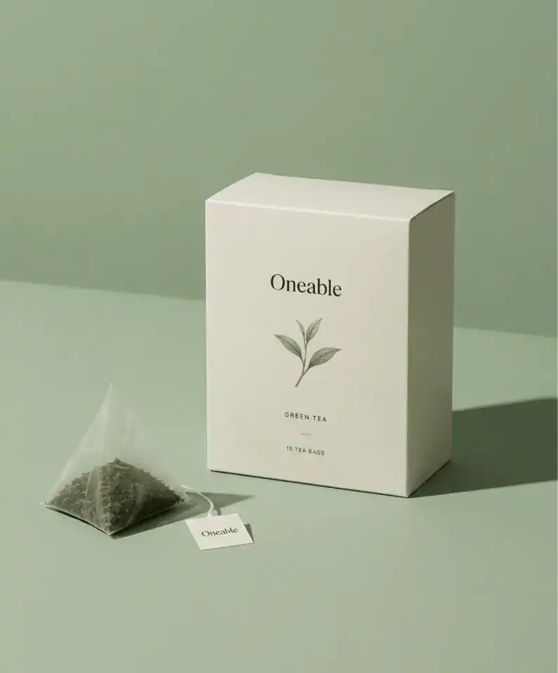 AI-generated product packaging photo of a green tea box and pyramid tea bag on a sage green background
